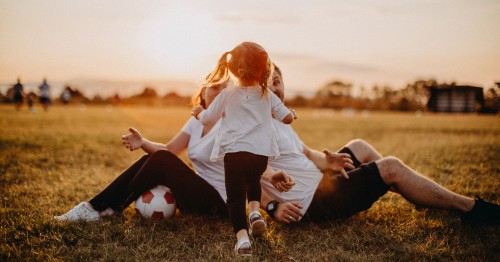 Familia sentada en un campo al atardecer