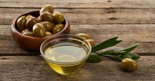 Cuenco de olivas y aceite de oliva sobre una mesa