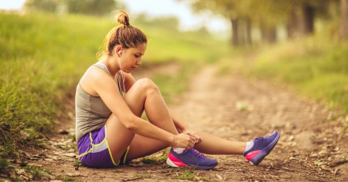 Mujer joven con ropa de deporte atándose las zapatillas