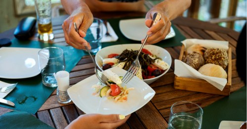 Pareja comiendo platos mediterráneos, que han demostrado ser beneficiosos para retrasar el Alzheimer