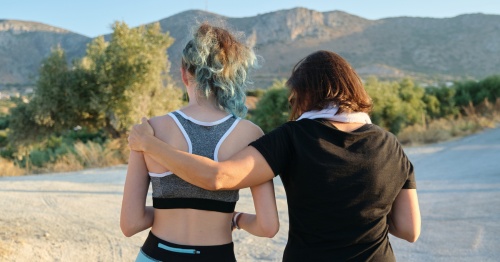 Madre e hija de espaldas practicando ejercicio al aire libre para combatir los radicales libres