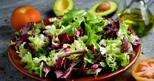 Foto de un plato de lechuga, tomate, aguacate y aceite de oliva, alimentos que explican por qué la Dieta Mediterránea es saludable